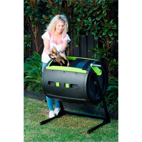 Woman using City Sleek Two Stage Compost Tumbler For Fast, Foolproof Outdoor Composting With Aeration Holes, Rust Proof Metal Plastic