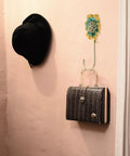 Sweet Vintage Flower Wall Hooks That Are Dang Handy For Hanging Coats Keys And Kitchen Towels Without Taking Up Valuable Space Plus The Rustic Design Looks Totally Legit In Any Room, showcasing a black hat and purse.