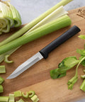 Built Tough Serrated Paring Knife Duo Featuring Premium High Carbon Stainless Steel Blades That Tear Through Tough Fruit And Veggie Skins Without A Sweat With Sleek Black Handles Pack Of Two on cutting board with celery.