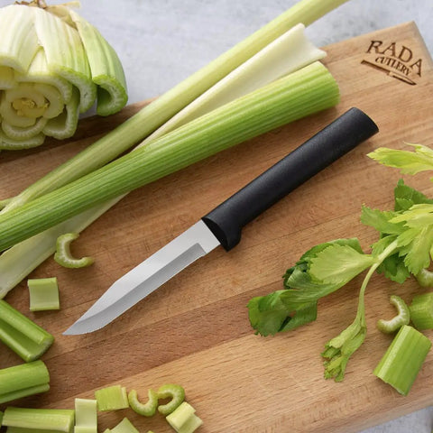 Built Tough Serrated Paring Knife Duo Featuring Premium High Carbon Stainless Steel Blades That Tear Through Tough Fruit And Veggie Skins Without A Sweat With Sleek Black Handles Pack Of Two on cutting board with celery.