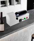 Straight Up Pro 110V Wine Bottle Cap Shrink Sealer Machine with a wine bottle on a bar counter, compact design.