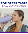 Woman drinking from a purple water bottle, promoting great taste and all-day hydration benefits.