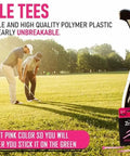 Pink Womens Golf Tees 50 Count with 40 Tall Three and a Quarter Inch Tees and 10 Short One and a Half Inch Tees Near Unbreakable Plastic Four Prong with Stripes Great for Drivers Fairways Irons and Par 3 Play on a golf course with players in background.