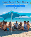 Group under Big 14x11 Foot Beach Shade Shelter With UPF50 Protection by the ocean, supported by aluminum poles and sandbags.