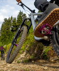 Mountain biker on trail using Ultra Thin Mountain Bike Clip Pedals Orange With Extra Large DH Sized Platform 26.8mm Profile.