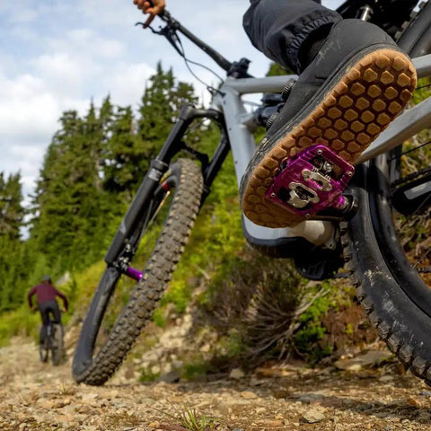 Mountain biker on trail using Ultra Thin Mountain Bike Clip Pedals Orange With Extra Large DH Sized Platform 26.8mm Profile.