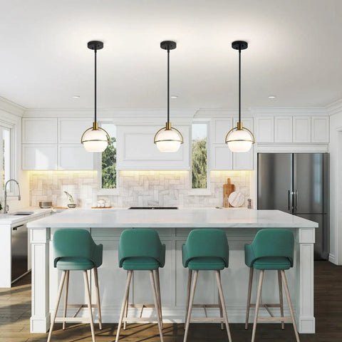 Yuniexuber 2 Pack Modern Mid Century Globe Pendant Lights in brass gold and black over a kitchen island with white glass shades.