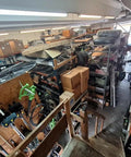 Warehouse with shelves of assorted construction and outdoor equipment, including boxed items and cables, ready for shipment.