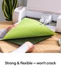 Person using Standard Grip Adhesive Cutting Mat 12x12 Inch Green 3 Pack For Vinyl Patterned Paper Iron On Cardstock with cutting machine.