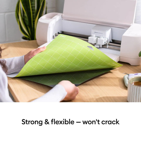 Person using Standard Grip Adhesive Cutting Mat 12x12 Inch Green 3 Pack For Vinyl Patterned Paper Iron On Cardstock with cutting machine.