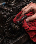 Hand using Extra Absorbent 13x17 Inches 12 Pack 100 Percent Cotton Shop Towels Reusable Cleaning Rags on greasy machinery.