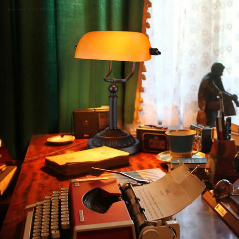 Amber Glass Bankers Desk Lamp With Retro Weighted Base And Old School Vibe on vintage desk with typewriter, E26 Base, matte orange shade