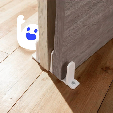 4 Pack Universal Sliding Door Bottom Guide In White ABS Floor Track For One And Three Eighths Inch Thick Closet And Cabinet Doors Includes Mounting Screws And Side Support To Keep Doors Centered And Sliding Smoothly shown installed on wooden floor, guiding closed doors.