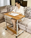 Height Adjustable Rolling Laptop Stand With Locking Wheels Folds Flat For Bed Or Couch used for writing on a couch.