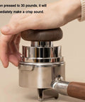 Knockout Espresso Gear Set Featuring Self Leveling Rotary Distributor And Calibrated Weighted Tamper showing user pressing on tamper with wood handle.