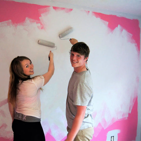 Couple painting wall using All In One Paint And Primer Gallon White For Indoor And Outdoor Use Adheres To Wood Tile Concrete Stucco