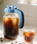 Glass pitcher with blue lid containing iced coffee, Two Pack 64 Oz Wide Mouth Pitchers With Stainless Steel Filters.