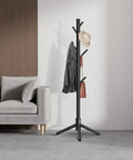 Freestanding Coat Rack With 8 Hooks And 3 Adjustable Heights in living room, holding hat, coat, and bag, black finish.