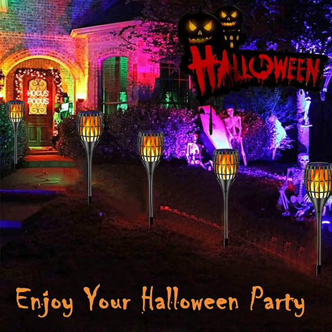 Sun Powered Solar Torch Lights With Realistic Flickering Flame Effect illuminating a Halloween-themed garden pathway, 43 inches tall, waterproof, dusk to dawn auto on off, perfect for yard paths and patio, 2 pack.