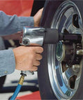 Using a Double Head Air Impact Wrench Half Inch Drive Pneumatic Ratchet 600Nm Torque on a tire for quick repairs.