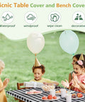 Children celebrating at a party with a Picnic Table Cover With Bench Covers 72x30 Inches 3 Piece Set Elastic Edges Fitted, outdoors.