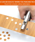 Pro Grade Heavy Duty Single Hole Puncher For Paper Cardboard And PVC creating clean 3/8 inch holes in brown cardboard.