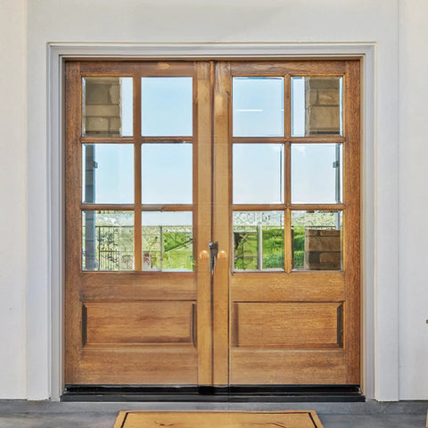 Double wooden doors with glass panels and a polished handle, showcasing a modern entrance design.