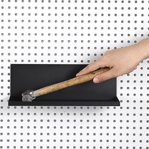 Hand placing a hammer on a Six Pack Magnetic Pegboard Shelf with lip edge for garage and workshop, metal pegboard tray, wall mount.
