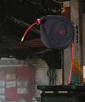 Heavy-Duty Retractable Air Hose Reel 50Ft 3/8 Inch Polymer Line Solid Brass Fittings mounted on a garage wall with hose extended