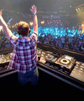 DJ performing on stage with Six Channel Bluetooth DJ Mixer And USB Audio Interface For Home Studio Recording Portable Digital Mixing Console With Independent Channel Gain EQ FX Send And Master Control PMXU68BT in crowded club.