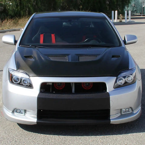 Front view of a car featuring 2005 To 2010 Scion tC LED Halo Projector Headlights Upgrade Kit with black housing and angel eye rings.