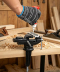 Badass 3.2 Inch Bench Vise With Fully Swiveling 360 Rotation And Grippy Soft Jaws, hand applying glue on a wooden piece in workshop.