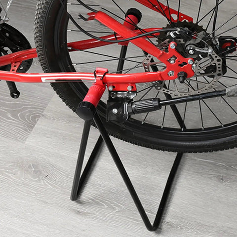 Garage Ready Vertical Triangle Bike Stand For Indoor Parking And Maintenance holding a red bike by rear wheel on wooden floor