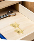 Super Cool 2 Piece Golden Zinc Alloy Duckbilled Toggle Latch Sets For Secure Wooden Cases, showing latches on a wooden drawer with a tool.