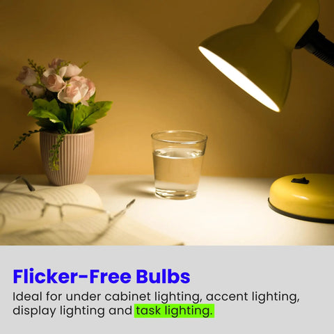 Table lamp shining on a desk with flowers, book, and glass, emphasizing 20 Watt Xenon Halogen G8 Bi Pin Light Bulbs usage for task lighting.