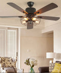 Stunning 52 Inch Retro Industrial Ceiling Fan Featuring Vintage Caged Shades And Five Reversible Solid Wood Blades With Slick Remote Controlled LED Light Kit For A Total Home Glow Up in stylish living room with floral armchair.