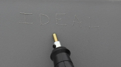 Electric Engraver With Carbide Tipped Point, 120V 60Hz, 7200 SPM engraving the word 'IDEAL' on gray surface