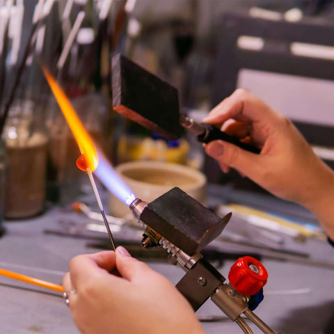 Close-up of hands using a torch for glasswork with High Purity Graphite Block Disk Ingot 50x5mm Electrode Plate Sheet