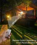 JUDYSSY 30W Led Solar Powered Flood Lights illuminating a house with remote control operation up to 88 feet, night setting.