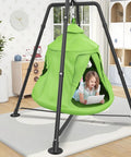 Child playing on an Outdoor Swing Set With Tent Swing And X Shaped Frame Sensory Swing indoors, featuring a green tent swing.