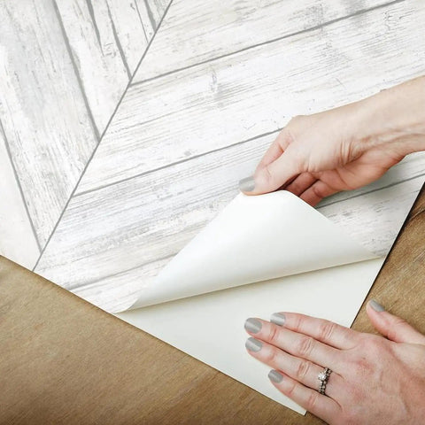 White And Tan Herringbone Wood Look Peel And Stick Wallpaper For Renters And Homeowners, Removable Vinyl shown being peeled back.