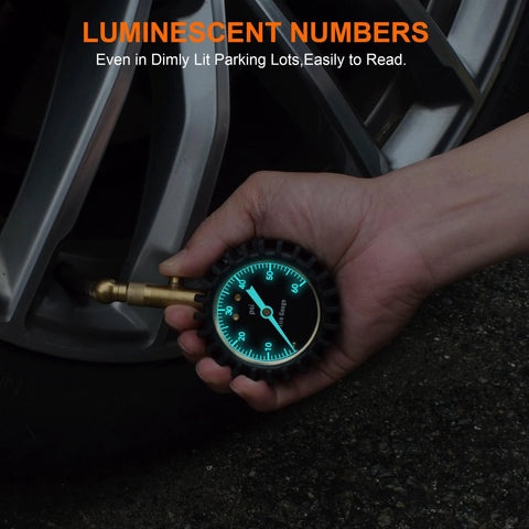 Tire pressure gauge with a 2-inch glowing blue dial, shown in a close-up near a car tire valve.