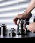 Person using a spring-loaded tamper from the Straight Up Pro Grade 58Mm Espresso Accessories Kit on a countertop.