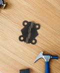 Antique Decorative Butterfly Hinges Set Of 24 For Jewelry Boxes And Cabinets, shown with tools on wooden surface