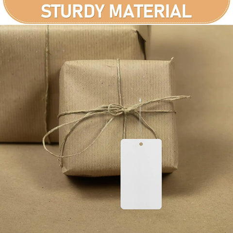 Blank White PVC Hanging Tags With Lanyard Waterproof 100 Pcs Jewelry Display Labels on brown wrapped packages.