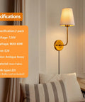 Antique brass wall sconce with white shade next to a window and cushions, 2-pack, plug in or hardwired, 120V, E26 base.