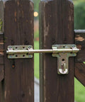 Badass Heavy Duty Slide Bolt Latch For Secure Garden Gates Barn Doors And Tight Garage Closures Featuring Smooth Manual Operation And Rust Proof Weathered Coating installed on wooden gate.