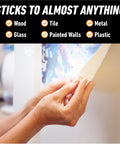 Applying mounting putty to wall for hanging decor, shows 'sticks to almost anything' features; Mounting Putty For Walls Natural Tan Color 168 Pre Cut Squares Removable And Repositionable Non Toxic Low Residue No Mess No Holes Lets You Hang Lightweight Decor And Pictures Without Nails Or Tape.