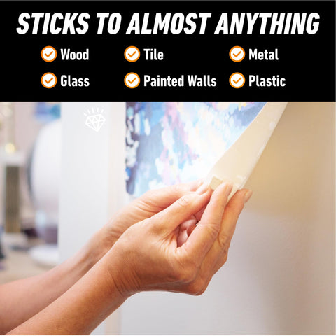 Applying mounting putty to wall for hanging decor, shows 'sticks to almost anything' features; Mounting Putty For Walls Natural Tan Color 168 Pre Cut Squares Removable And Repositionable Non Toxic Low Residue No Mess No Holes Lets You Hang Lightweight Decor And Pictures Without Nails Or Tape.
