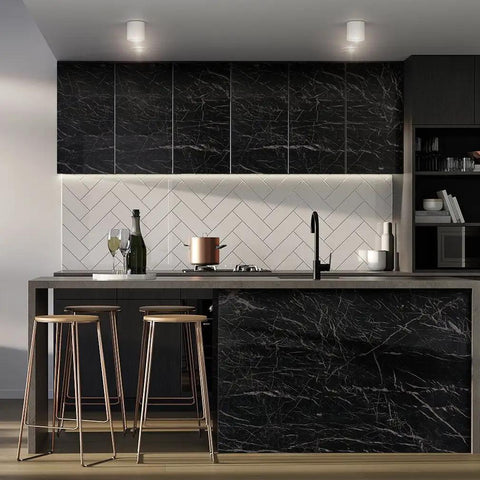 Black marble kitchen countertop and cabinet with wine bottle, glass, and cookware.